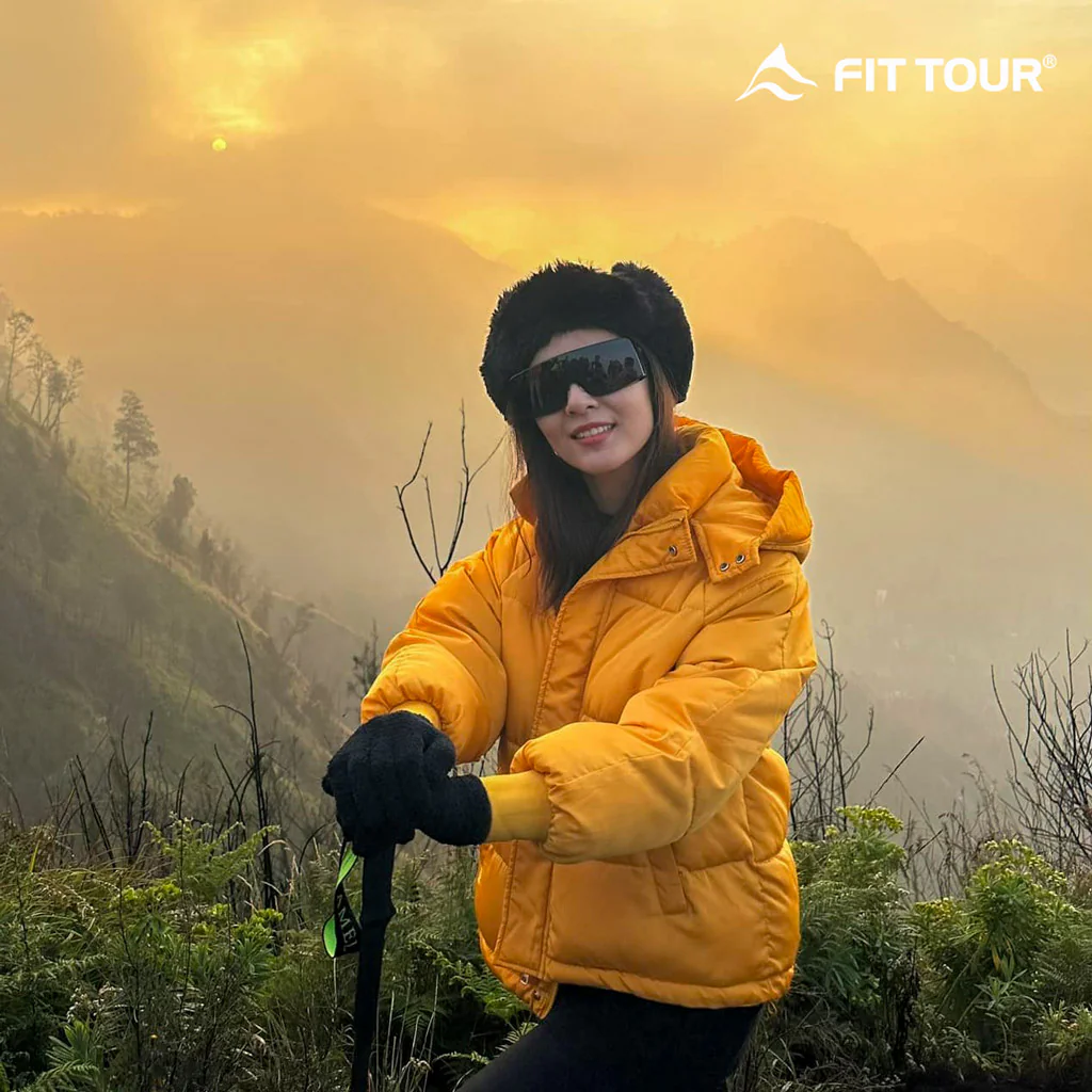 Nữ du khách đón bình minh trên đường hiking đến hồ axit Kawah Ljen ở Indonesia