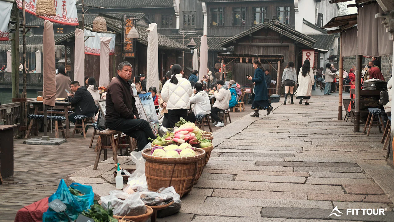 Khu chợ địa phương tại Ô Trấn, Giang Nam, với các quầy hàng rau củ và không gian nhộn nhịp