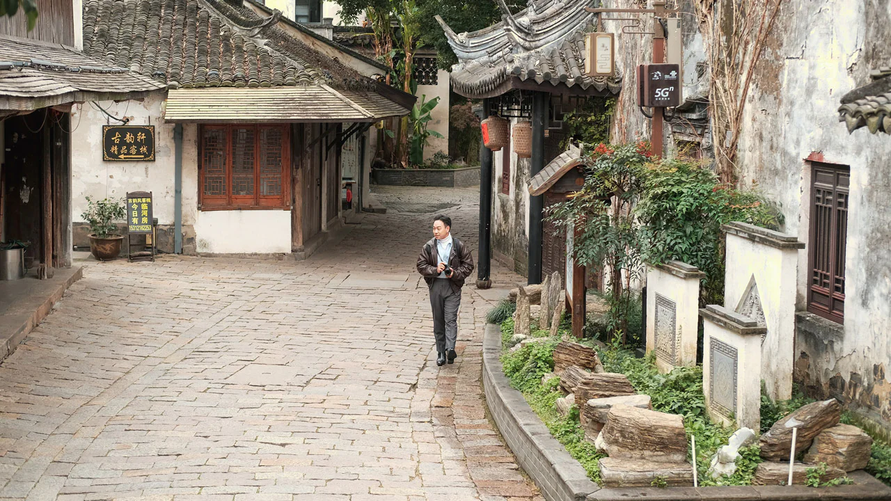 Một du khách đi bộ trên đường lát đá tại Thị trấn cổ Châu Trang, Trung Quốc, với khung cảnh nhà cổ truyền thống