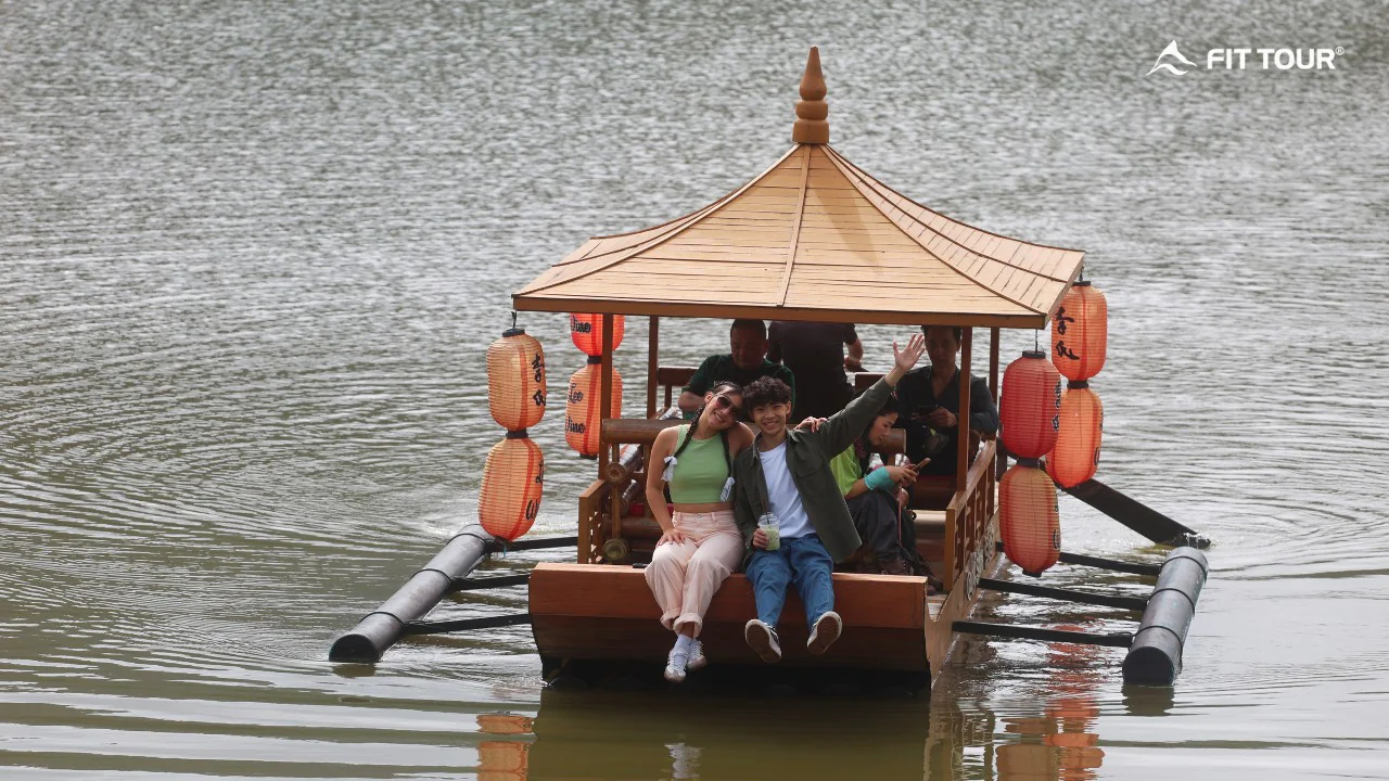Du khách trải nghiệm đi thuyền gỗ mái che treo đèn lồng đỏ trên hồ Ban Rak Thai, Mae Hong Son, Thái Lan