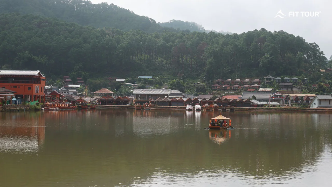 Toàn cảnh hồ trung tâm làng Ban Rak Thai với nhà gỗ và đồi thông bao quanh ở Mae Hong Son, Thái Lan