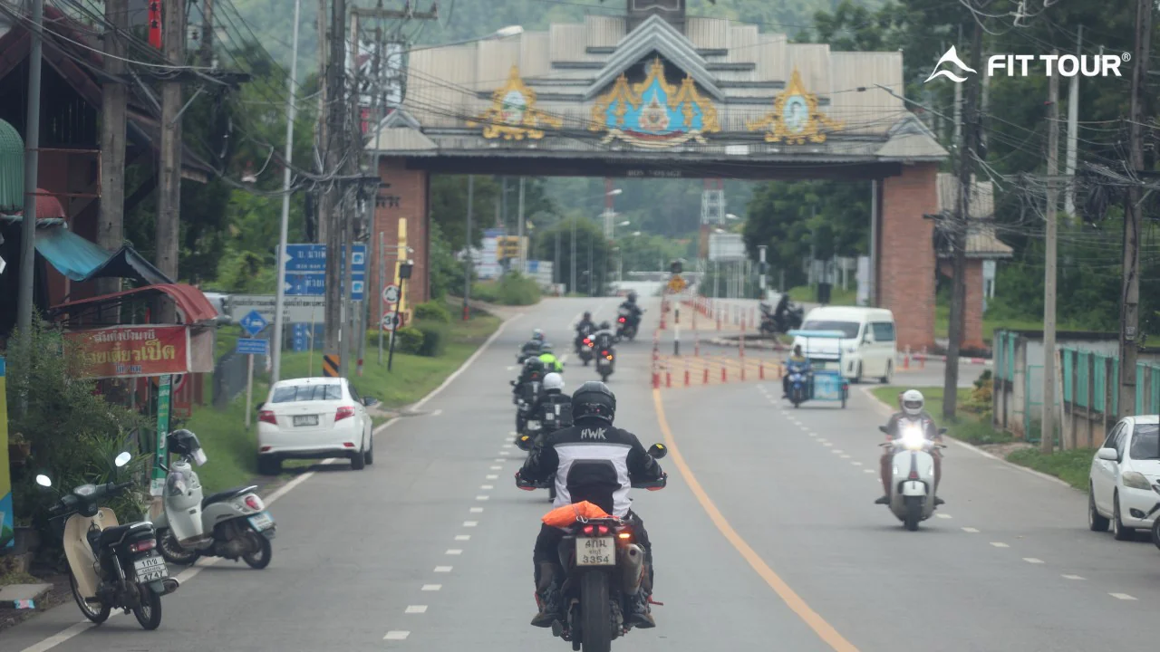 Đoàn mô tô di chuyển qua cổng thị trấn phong cách Thái trên cung đường khám phá Chiang Mai