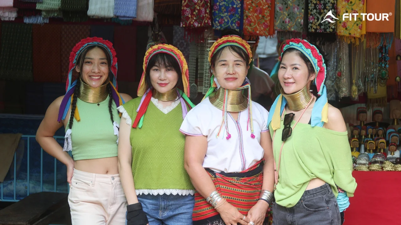 Nhóm phụ nữ Karen cổ dài mặc trang phục truyền thống, cùng du khách chụp ảnh lưu niệm tại làng Long Neck Karen, Mae Hong Son, Thái Lan