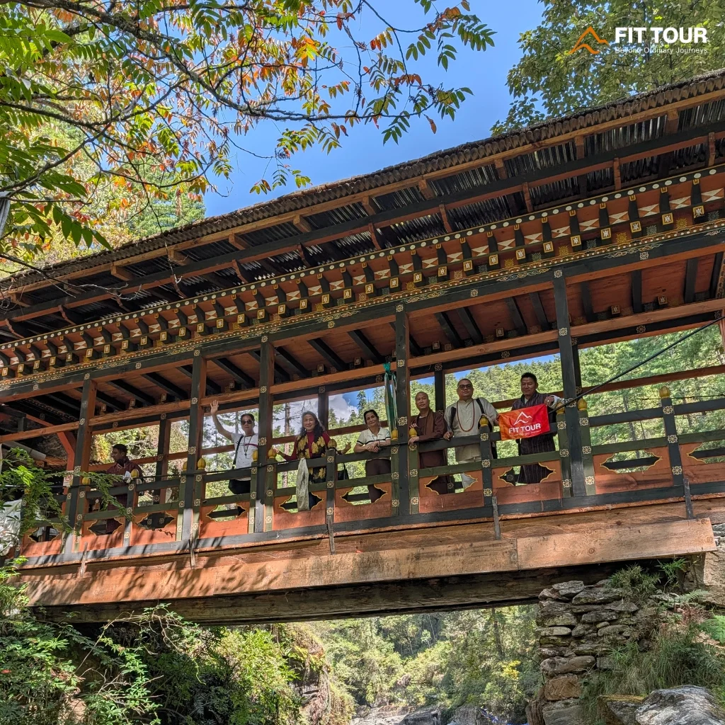 Cầu gỗ bắc qua hẻm Mebar Tsho thung lũng Tang Bhutan với cờ cầu nguyện trong gió