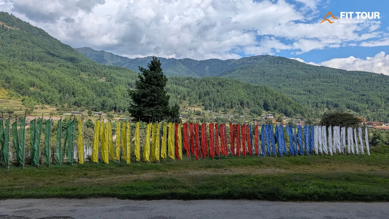 Dãy cờ cầu nguyện ngũ sắc tung bay rực rỡ bên sườn đồi gần Kurjey Lhakhang Bumthang Bhutan