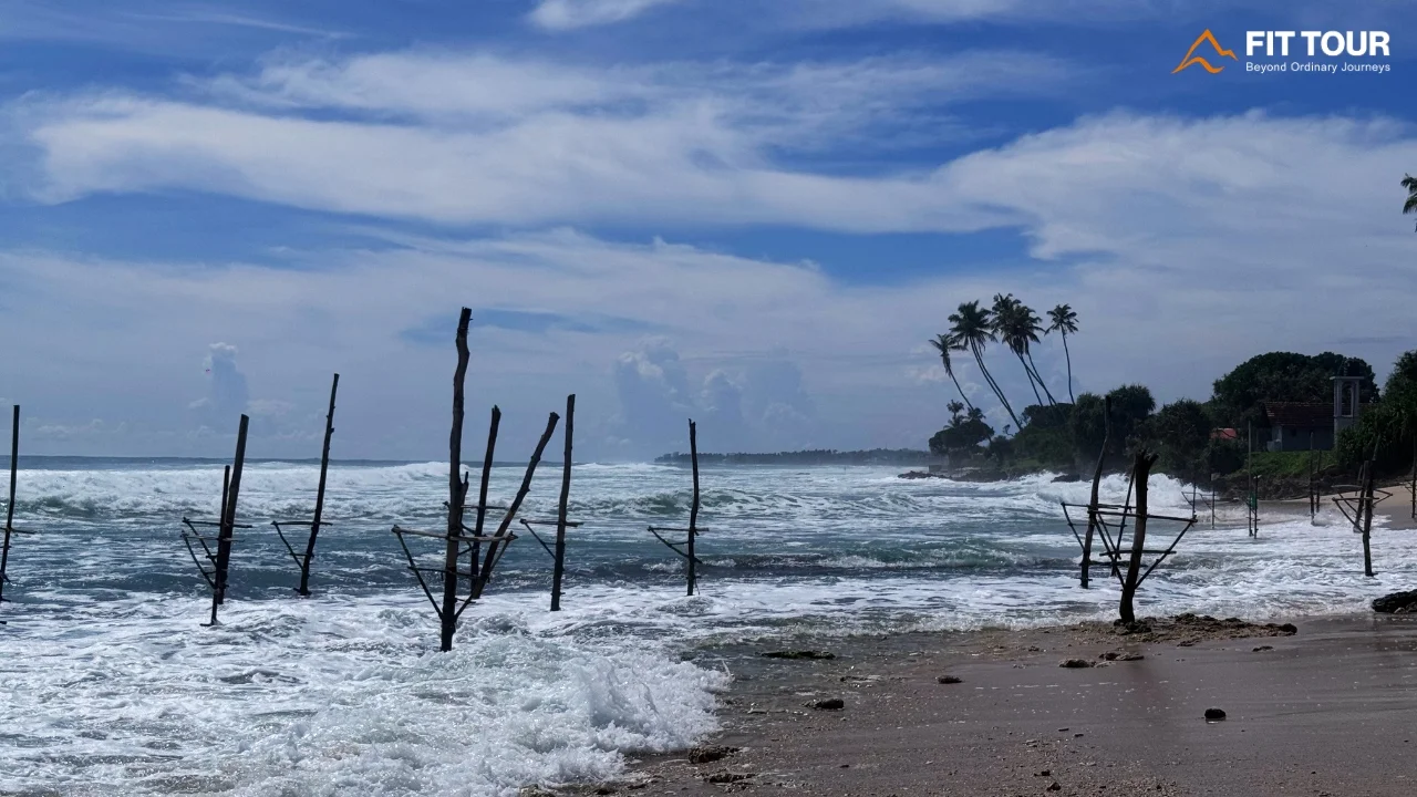 Hệ thống cọc gỗ câu cá cà kheo dọc bờ biển Sri Lanka dưới trời xanh