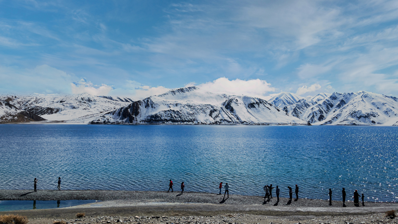 Khách du lịch đi bên hồ Pangong Tso