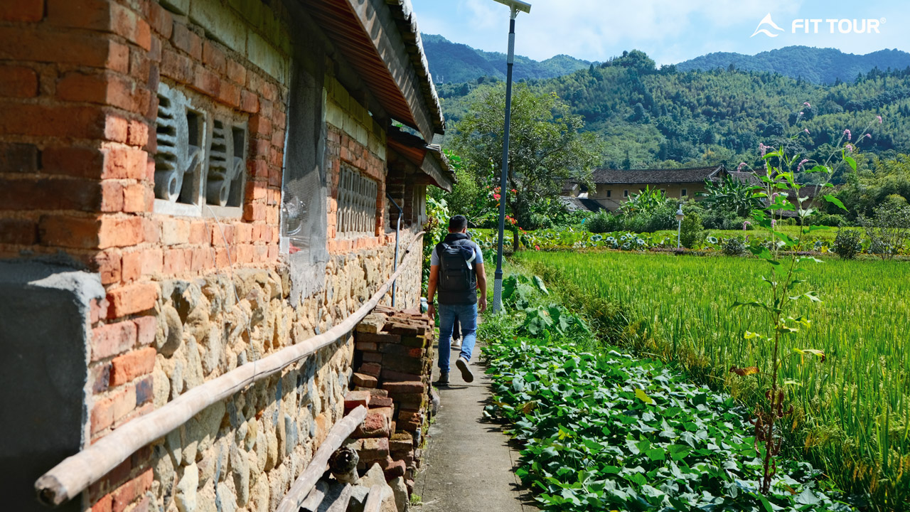 Lối dạo lát đá cuội men theo vườn hoa dẫn lối vào làng